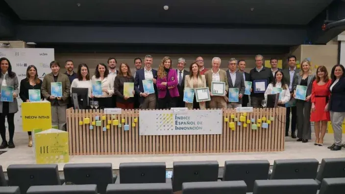 Ganadores y expertos en el evento del Índice Español de Innovación posando con sus reconocimientos en un auditorio.