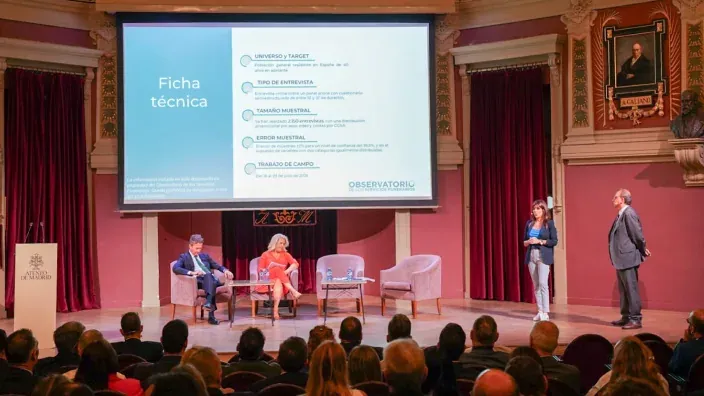 Presentación de un informe en el Ateneo de Madrid. Un panel de expertos debate mientras una ponente expone la ficha técnica del estudio.