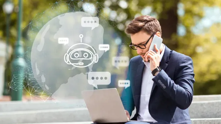 Empresario trabajando al aire libre con portátil y móvil asistido por chatbot virtual de IA.