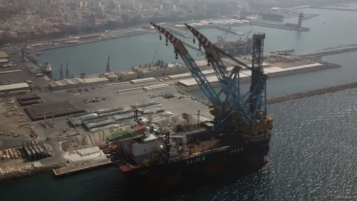 Infraestructura portuaria de Almería con buques y grúas vinculada al transporte de gas y energía.