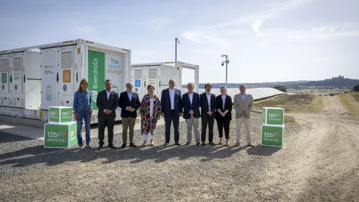 Grupo de personas posando junto a contenedores de almacenamiento energético de Iberdrola en una instalación al aire libre