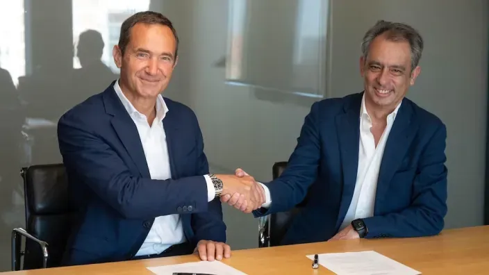 Directivos de Naturgy y Moeve estrechando la mano tras firmar un acuerdo.