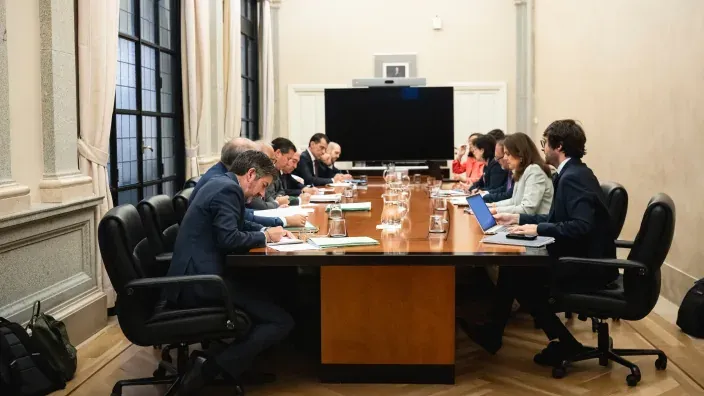 Vista general de una reunión formal entre representantes energéticos y técnicos frente a una gran pantalla