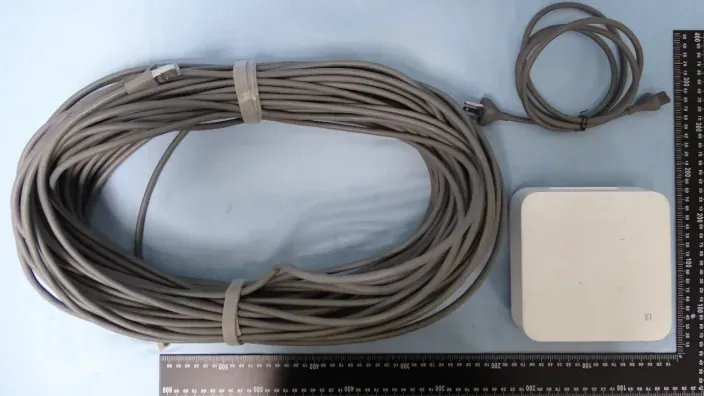 Kit de red: bobina de cable Ethernet gris, cable de alimentación y router Amazon Leo compacto blanco para conectividad.