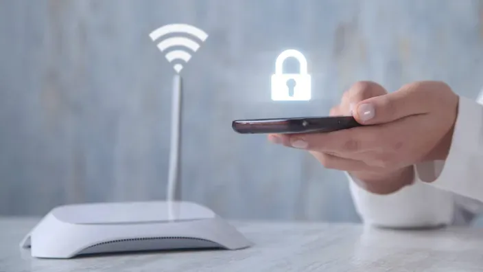 Router WiFi y smartphone con icono de candado que simboliza una conexión a internet segura.