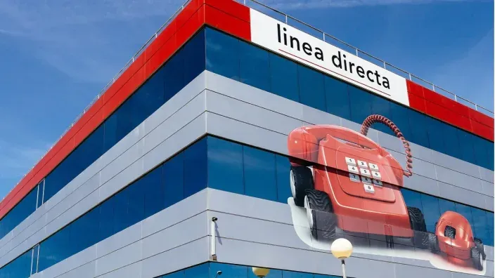 Fachada del edificio de la sede de la aseguradora Línea Directa, con su logo y la imagen de su icónico teléfono rojo.