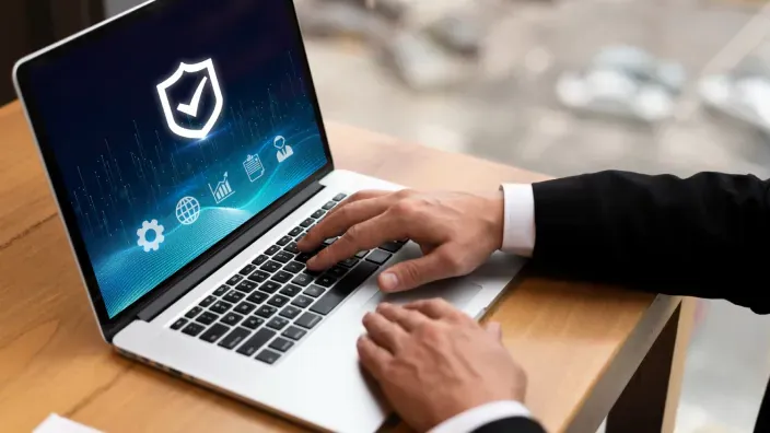 Profesional protege sus datos en el portátil con un antivirus y un escudo de seguridad.