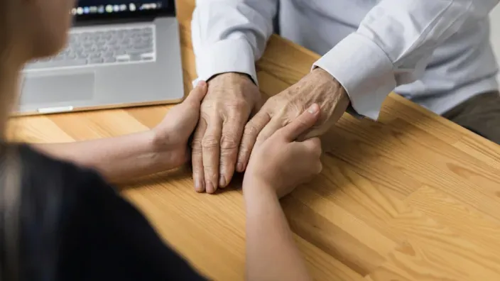 Asesor financiero o familiar ayudando a una persona mayor a planificar su seguro de dependencia.