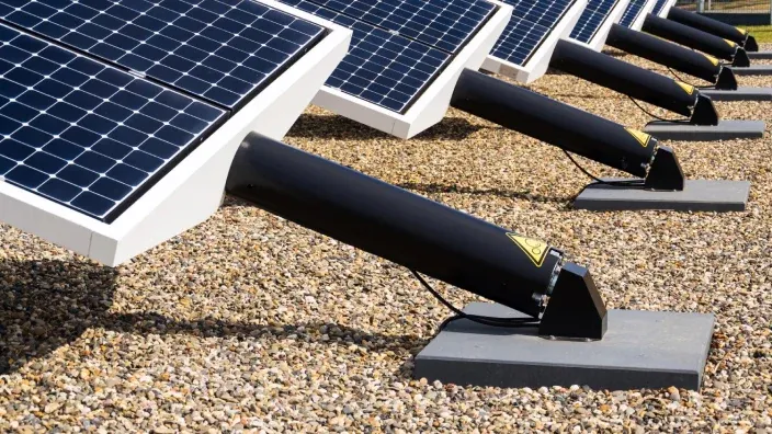 Filas de paneles solares montados sobre estructuras inclinadas en una instalación fotovoltaica
