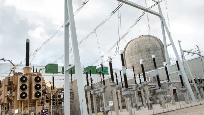 Subestación eléctrica junto a una central nuclear con equipos de alta tensión.