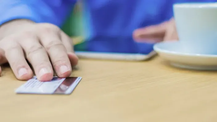 Primer plano de una persona pagando con su tarjeta de crédito.