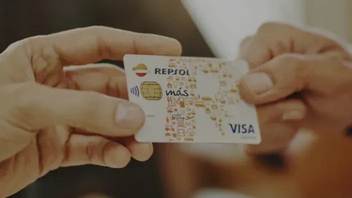 Dos manos sujetando la tarjeta Repsol Mas Visa.