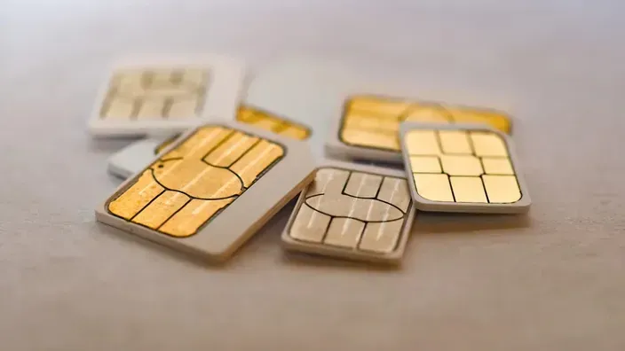 Primer plano de varias tarjetas SIM de diferentes tamaños para teléfonos móviles, mostrando el chip dorado de conexión.