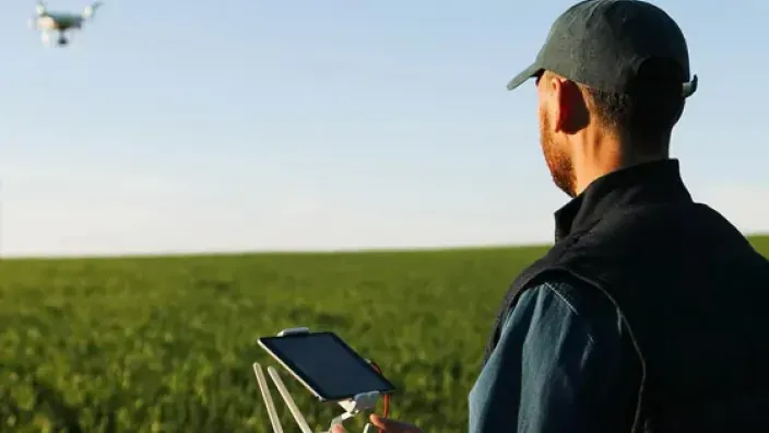 Agricultor usando un dron con tablet para la monitorización de cultivos.