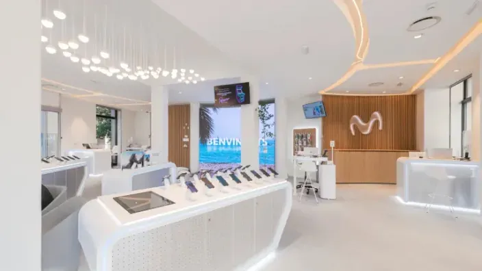 Interior de una tienda Movistar de Telefónica con exposición de móviles y atención al cliente