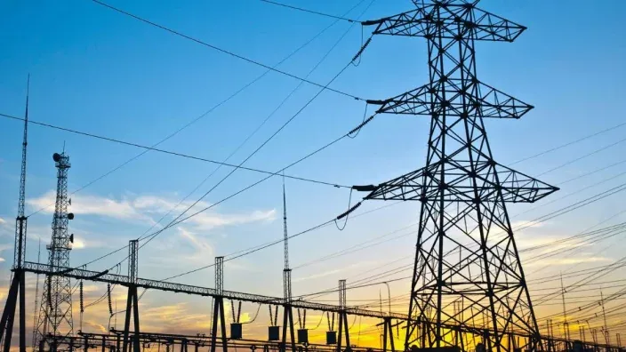 Torres de alta tensión y cableado eléctrico al atardecer.