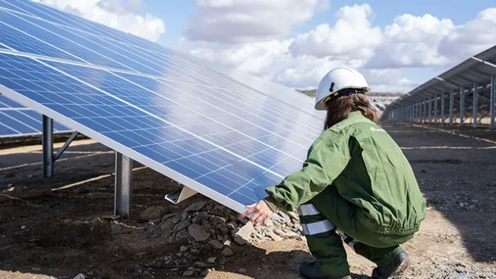 Trabajadora revisando paneles solares en planta fotovoltaica de Iberdrola.