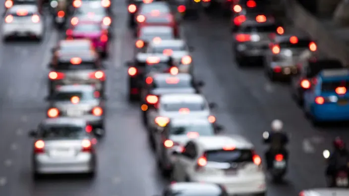 Tráfico intenso con retenciones y coches circulando lentamente en ciudad.