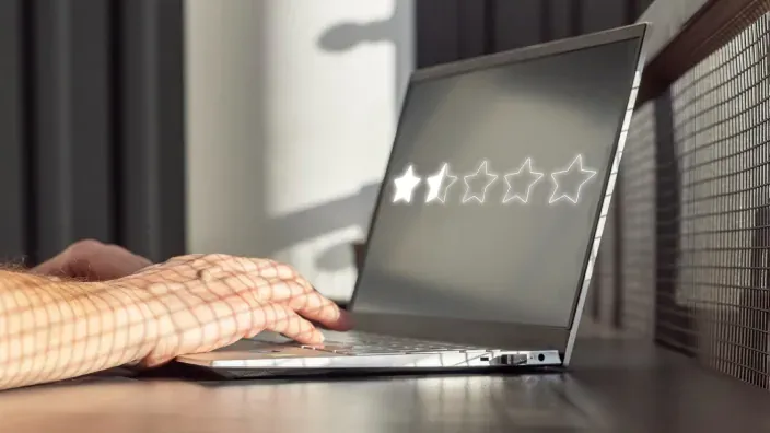 Usuario valorando con estrellas un servicio o producto en la pantalla de un ordenador portátil.