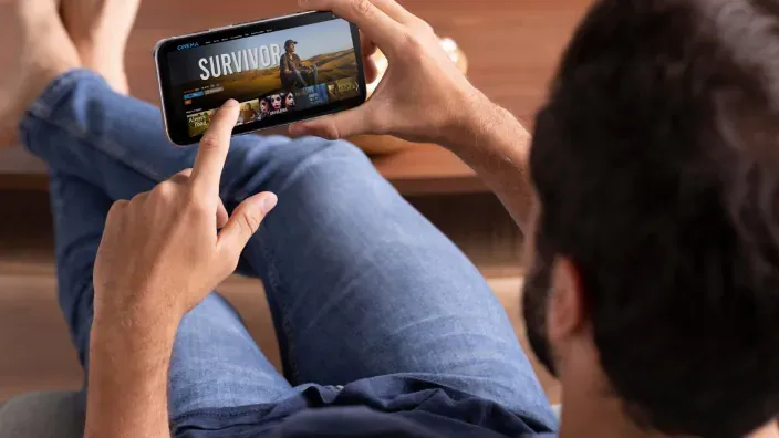 Persona viendo series en el móvil a través de una app de streaming