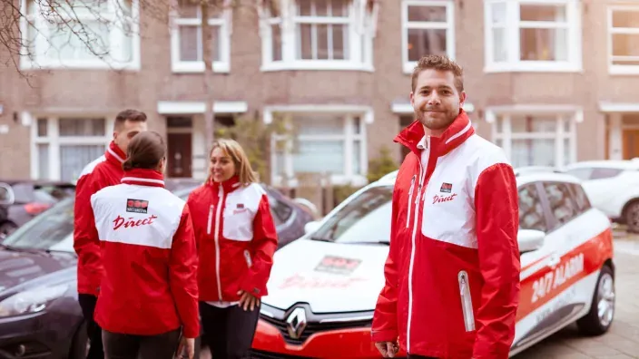 Equipo de técnicos de Securitas Direct con uniforme rojo y blanco junto a vehículo de empresa.