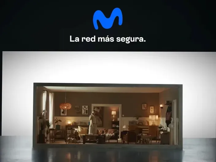 Anuncio de Movistar con el logotipo y el texto La red más segura sobre una escena de interior doméstico
