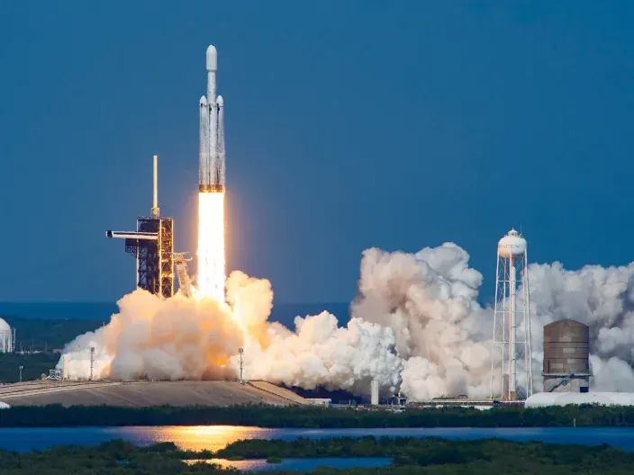 Cohete de SpaceX despegando desde una plataforma de lanzamiento junto a una gran nube de humo