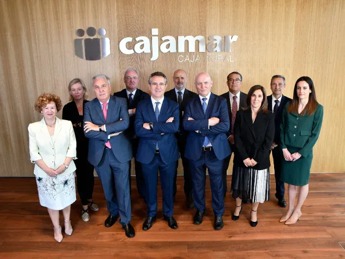 Consejo rector de Cajamar posando en la sede corporativa con el logotipo de la entidad al fondo