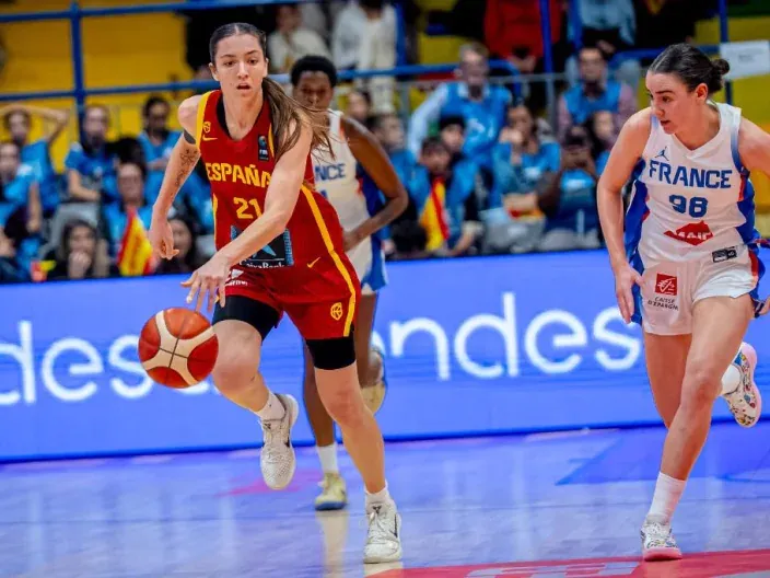 Jugadora de la selección española femenina de baloncesto avanzando con el balón ante la defensa de Francia en un partido internacional.