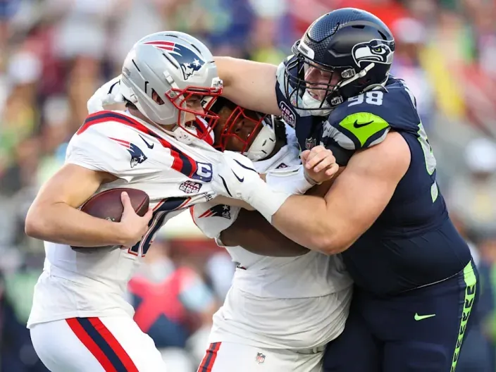 Jugadores de los New England Patriots y los Seattle Seahawks durante una jugada de un partido de fútbol americano