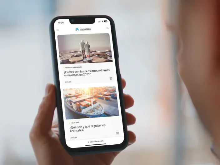 Persona consultando noticias financieras en la aplicación móvil de CaixaBank desde un smartphone.