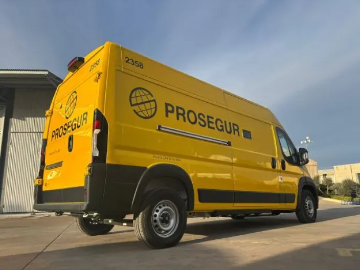 Furgón amarillo de Prosegur estacionado en un centro logístico para servicios de seguridad y transporte de valores.