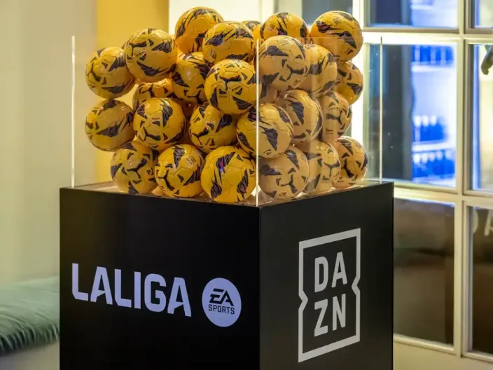 Expositor con balones de LaLiga en un evento, con los logos de LaLiga, EA Sports y DAZN, la plataforma para ver el fútbol.