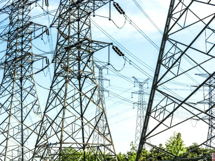 Torres de alta tensión y líneas eléctricas sobre un cielo despejado.