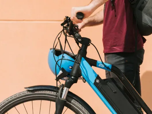 Primer plano de un hombre con su bicicleta eléctrica (e-bike).