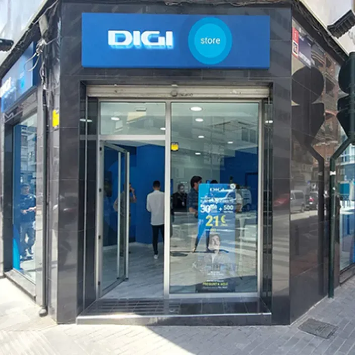 Fachada de una tienda DIGI store con oferta de fibra y móvil por 21 euros visible en el escaparate.