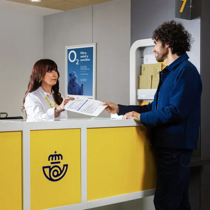 Trámites de O2 en Correos: un cliente contrata fibra y móvil en el mostrador de atención de una oficina postal.