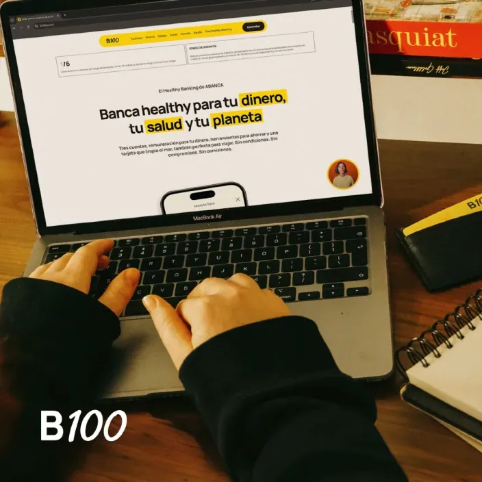 Persona usando la web de B100 en un portátil sobre una mesa