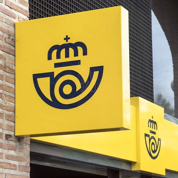 Rótulo de Correos en una fachada amarilla