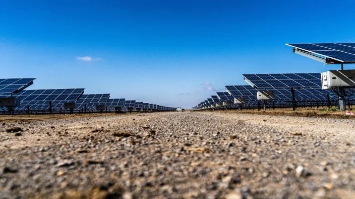 Planta solar con filas de paneles fotovoltaicos en un paisaje despejado.