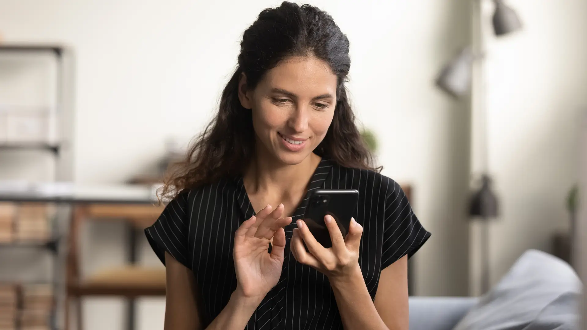 una joven manejando su alarma desde el movil porque aun no tiene el mando de su alarma con adt una joven manejando su alarma desde el movil porque aun no tiene el mando de su alarma con adt