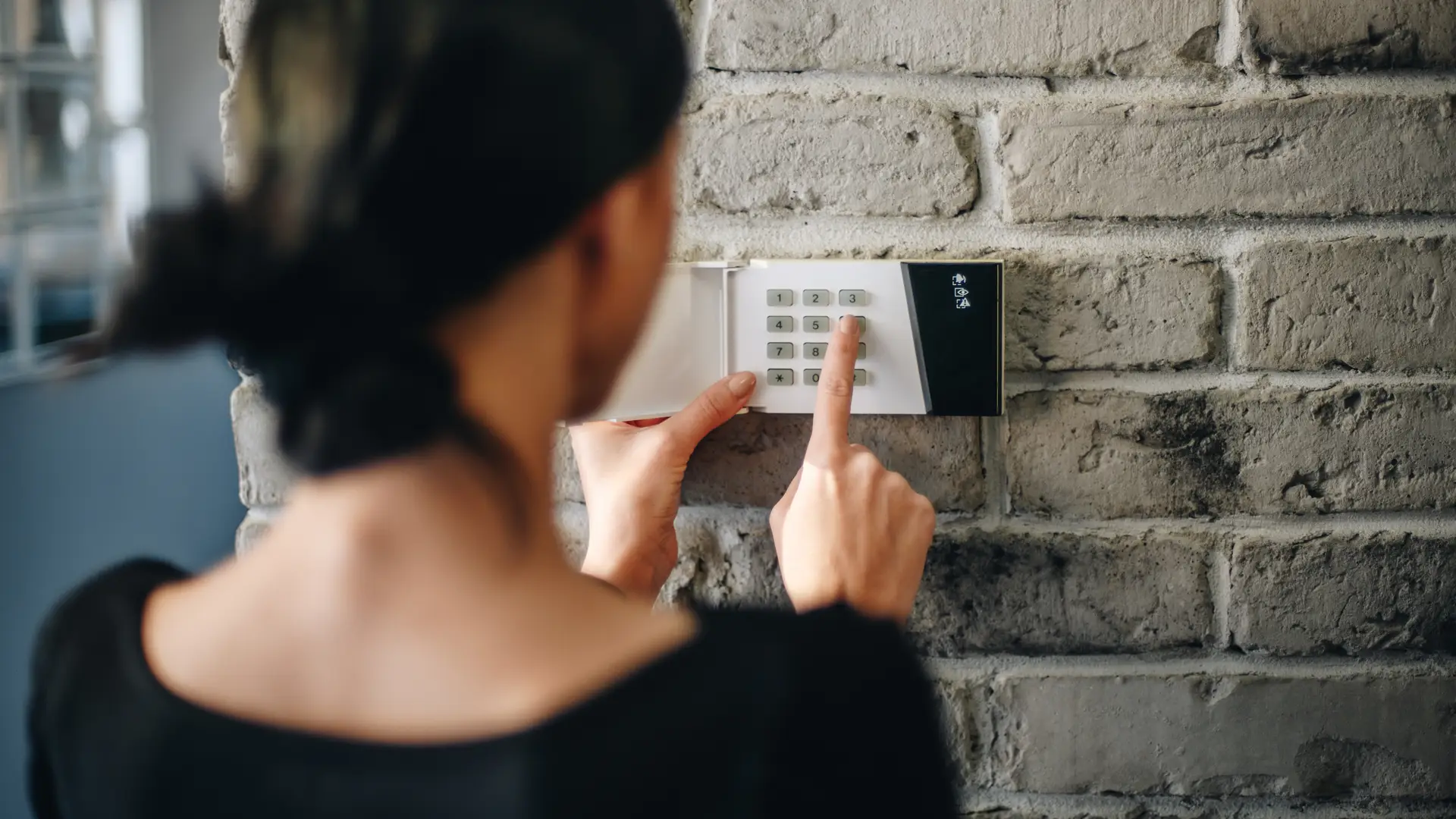 Mujer poniendo código de seguridad de su alarma de movistar prosegur anti-inhibición Mujer poniendo código de seguridad de su alarma de movistar prosegur anti-inhibición