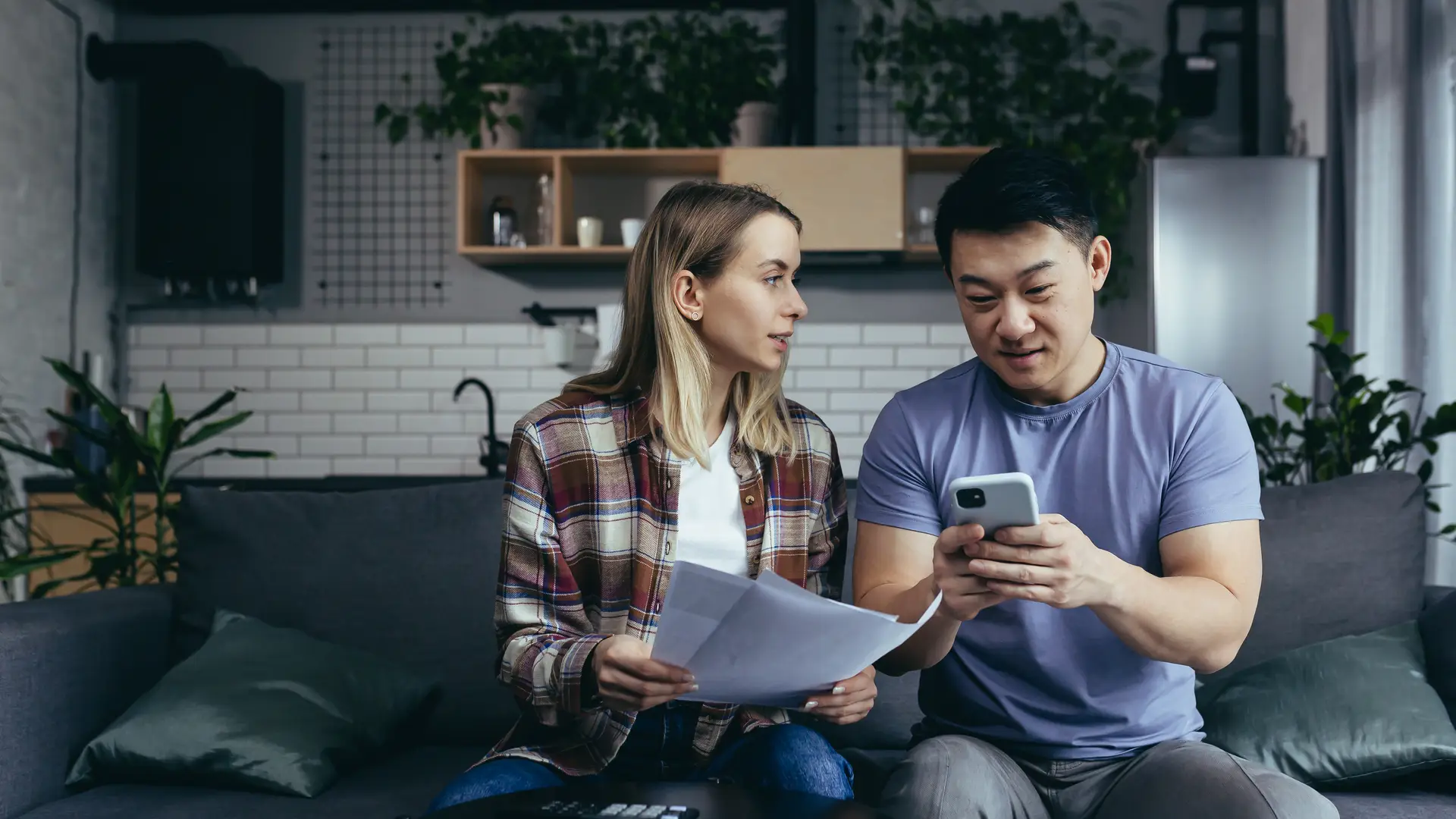 Una pareja comprueba sus facturas del mes incluida la de su tarifa de luz de Eleia desde el móvil