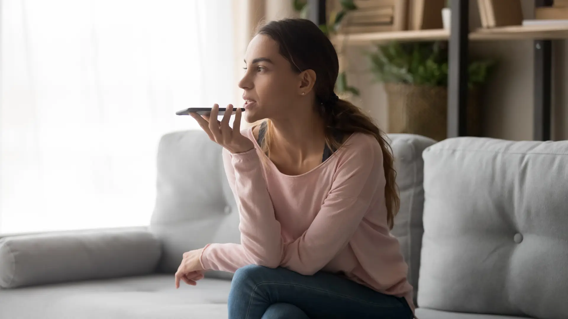 Mujer hablando por telefono desde el sofa de su casa para dar de baja su energia con la empresa Energia XXI Mujer hablando por telefono desde el sofa de su casa para dar de baja su energia con la empresa Energia XXI