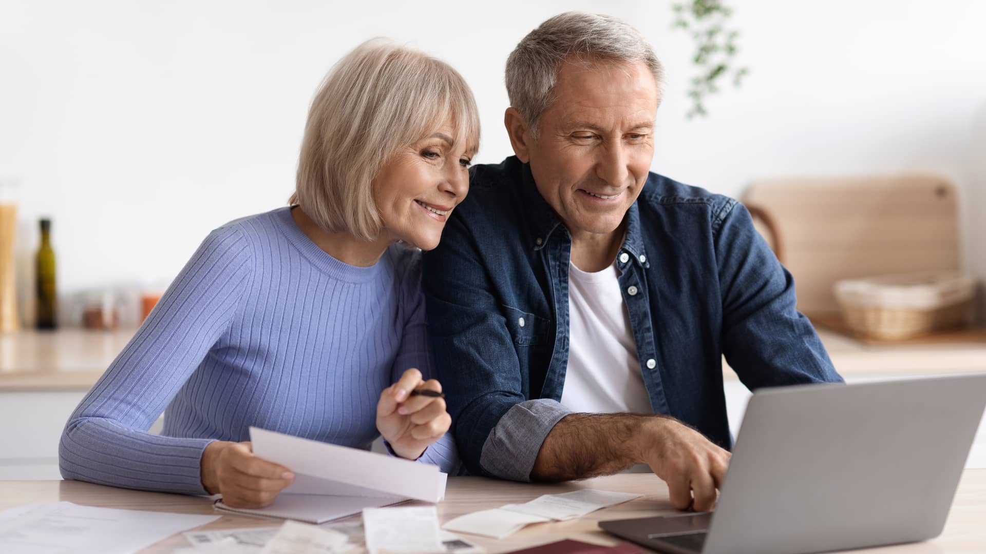 Una pareja de mediana edad revisa sus facturas del mes incluida su factura de luz de logos energía Una pareja de mediana edad revisa sus facturas del mes incluida su factura de luz de logos energía