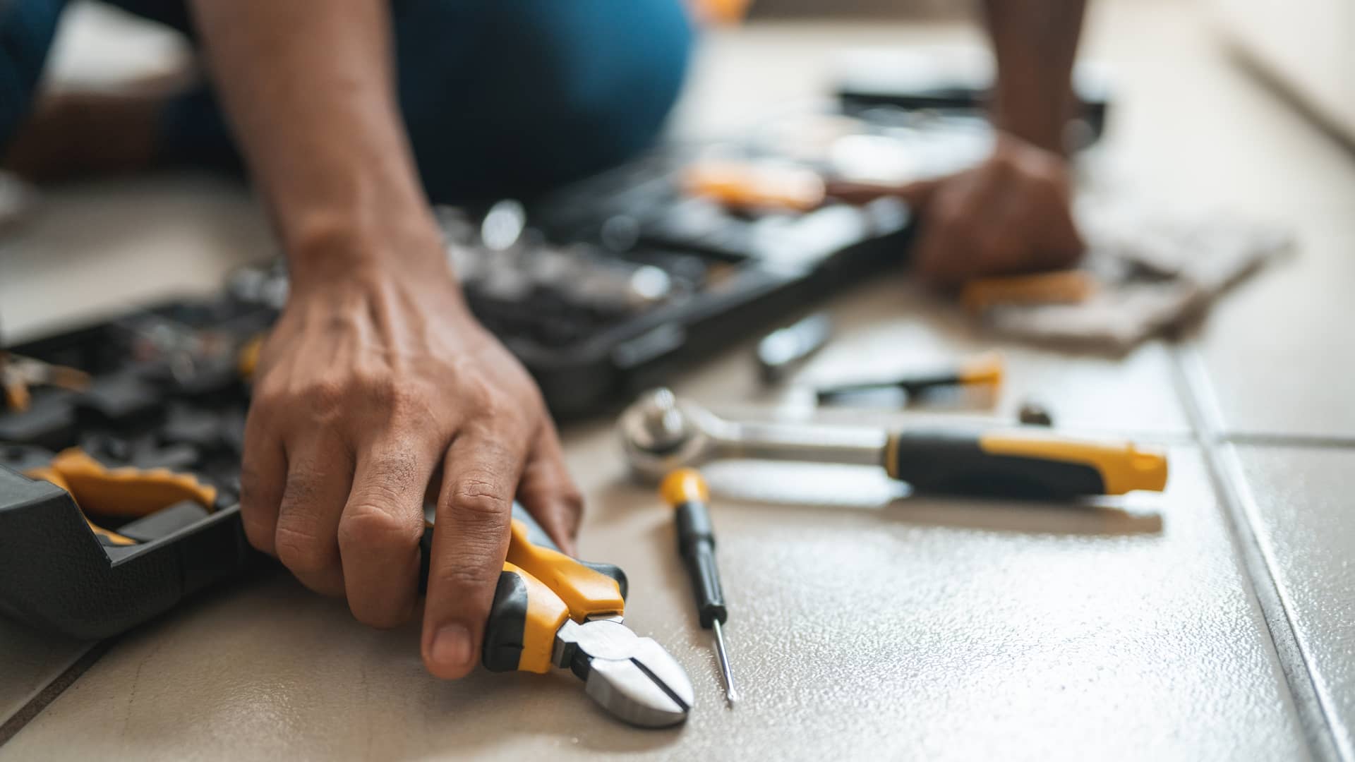 Técnico de servihogar con herramientas arreglando avería Técnico de servihogar con herramientas arreglando avería