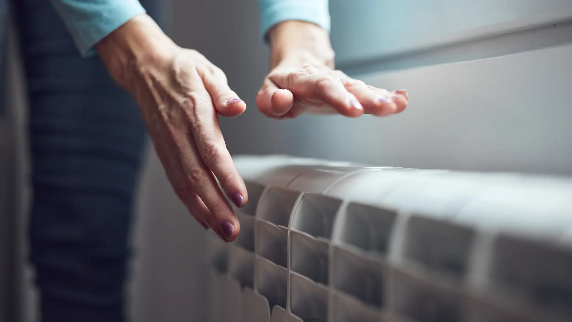 manos de una mujer calentandose en un radiador gracias a una de las tarifas tur de naturgy manos de una mujer calentandose en un radiador gracias a una de las tarifas tur de naturgy