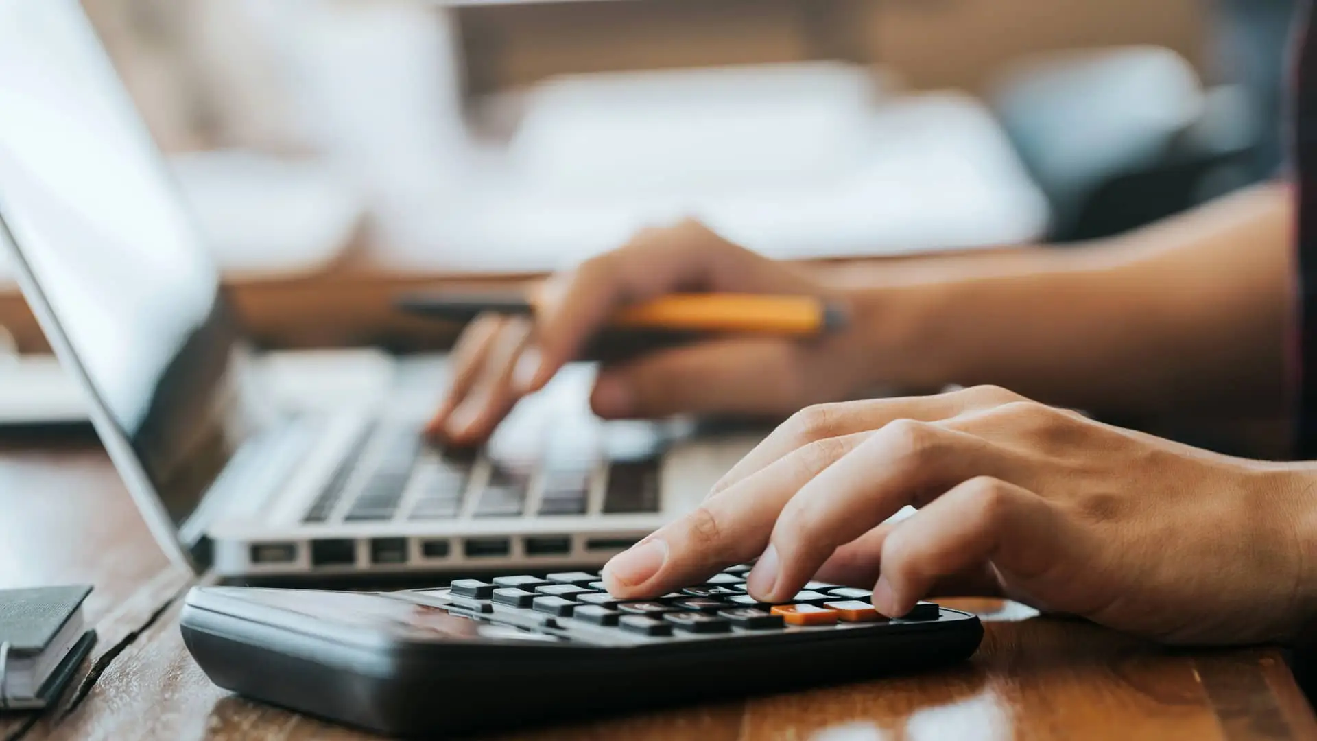 Persona revisando factura de regsiti con la calculadora Persona revisando factura de regsiti con la calculadora