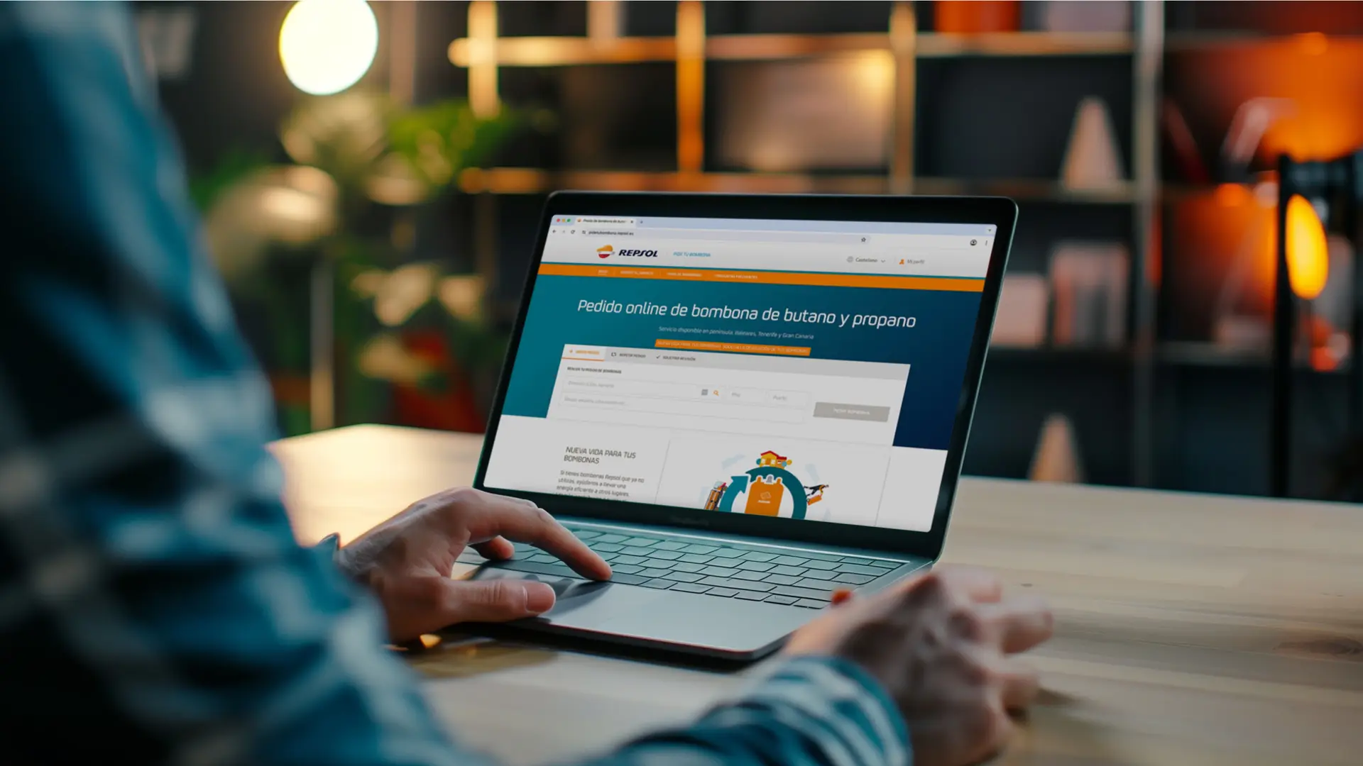 Un hombre contratando desde su ordenador las bombonas de butano de repsol.