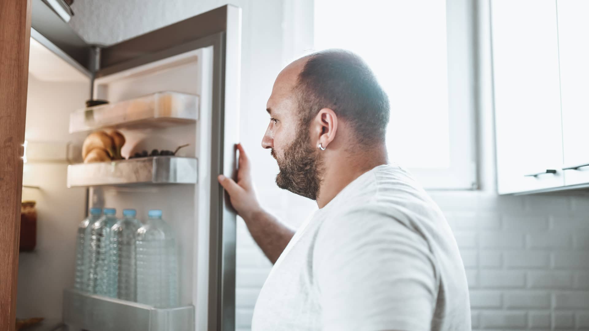 Cliente de unieléctrica abriendo la nevera Cliente de unieléctrica abriendo la nevera
